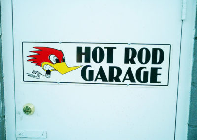 sign that says hot rod garage with roadrunner